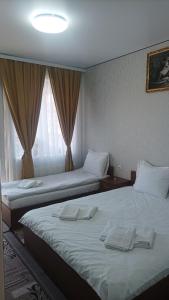 una camera d'albergo con due letti e una finestra di Готель Ассоль a Chmel'nyc'kyj