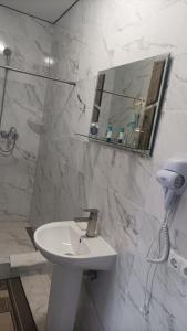 a white bathroom with a sink and a mirror at Готель Ассоль in Khmelʼnytsʼkyy