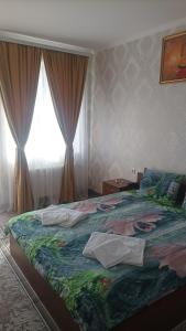 una camera con un grande letto e una finestra di Готель Ассоль a Chmel'nyc'kyj
