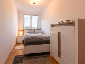 a small bedroom with a bed and a window at Mieszkanie Sopot Blue - ACCO RENT in Sopot