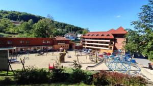 a playground in front of a hotel with a roller coaster at Hotel Ambra in Luhačovice