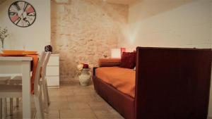 uma sala de estar com um sofá e um relógio na parede em More Apartments The Castle em Bari