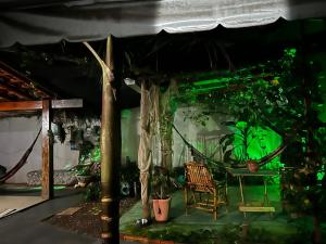 a room with a hammock and a table with plants at Pousada e Hotel Italian Garden House in Campo Grande