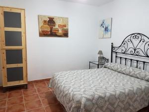 a bedroom with a bed and a picture on the wall at Casa de la Fuente in Almonaster la Real