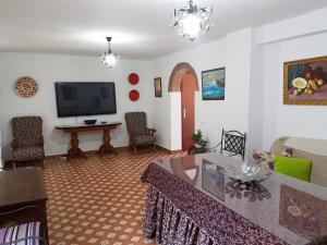 a living room with a table and a tv at Casa de la Fuente in Almonaster la Real