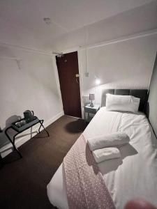 een slaapkamer met een groot wit bed en een tafel bij Harbour Hotel in Skegness