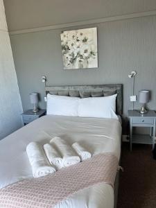 a bedroom with a white bed with towels on it at Harbour Hotel in Skegness