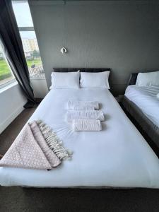 a bed with two pillows and towels on it at Harbour Hotel in Skegness