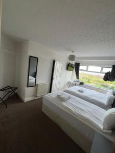 a bedroom with a large bed with a large window at Harbour Hotel in Skegness