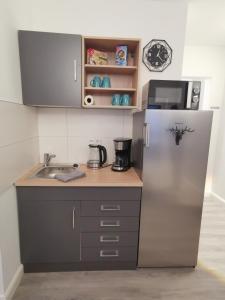 a small kitchen with a refrigerator and a sink at Airbnb, moderne, ruhige und helle Doppelzimmer, nähe Magdeburg, A14 & A2 in Dahlenwarsleben