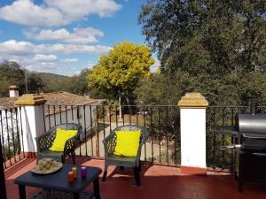 een balkon met 2 stoelen, een tafel en een grill bij Casa del escultor in Canaleja