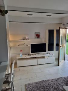 uma sala de estar branca com uma televisão sobre uma mesa em Residence Hotisstyle em Portorož