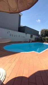 a large swimming pool in front of a building at Pousada e Hotel Italian Garden House in Campo Grande