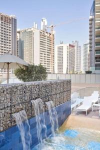 a swimming pool with water fountains on a building at Burj Khalifa View With 5star Flatwalk Dubai Mall in Dubai
