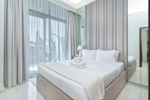 sypialnia z białym łóżkiem i dużym oknem w obiekcie Burj Khalifa View With 5star Flatwalk Dubai Mall w Dubaju