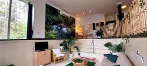 uma sala de estar com um sofá e uma televisão em Bed&Breakfast Kamersven em Maarheeze