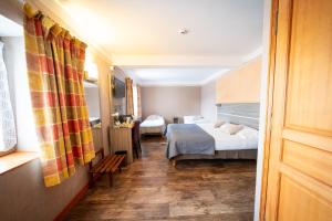 um quarto de hotel com duas camas e um corredor em Au Relais Nivernais em Nevers