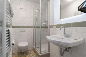 a white bathroom with a sink and a shower at Brauereigasthof Bären in Titisee-Neustadt