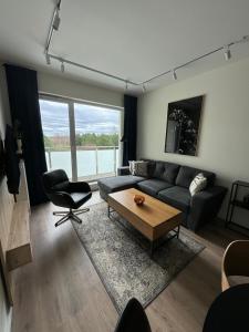 ein Wohnzimmer mit einem Sofa und einem Tisch in der Unterkunft Apartament Pileckiego 7b/37 in Suwałki