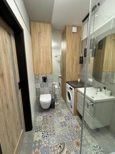 ein Badezimmer mit einem WC, einem Waschbecken und einer Waschmaschine in der Unterkunft Apartament Pileckiego 7b/37 in Suwałki