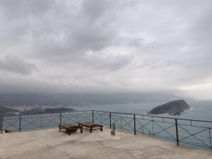 two benches on a balcony looking out at the ocean at High Hostel in Budva