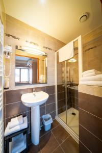 La salle de bains est pourvue d'un lavabo et d'une douche. dans l'établissement Au Relais Nivernais, à Nevers