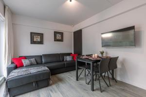 uma sala de estar com um sofá e uma mesa em Sunny apartment in Knokke-Heist with big terrace em Knokke-Heist