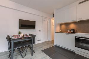 une cuisine avec une table et des placards blancs dans l'établissement Sunny apartment in Knokke-Heist with big terrace, à Knokke-Heist