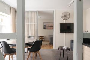 een woonkamer met een tafel en stoelen en een televisie bij The Brewer apartments by Daniel&Jacob's in Kopenhagen