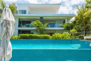 a swimming pool in front of a house at Seafront apt breathtaking view in Cap Malheureux in Cap Malheureux