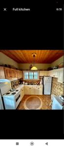 una gran cocina con electrodomésticos blancos y techos de madera. en Ionian Lefkada Sunset House flyMeRachi40m, en Exanthia