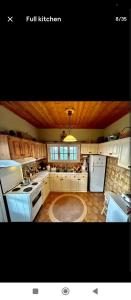 a large kitchen with white appliances and wooden ceilings at Ionian Lefkada Sunset House flyMeRachi40m in Exanthia