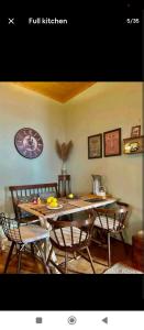a dining room table with chairs and a large clock on the wall at Ionian Lefkada Sunset House flyMeRachi40m in Exanthia +17 photos