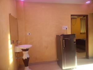 a bathroom with a sink and a small refrigerator at Golden villa in Calangute