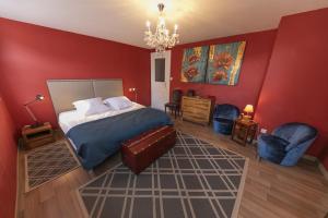 una camera da letto con pareti rosse e un letto e sedie di Origin'alsace a Kaysersberg