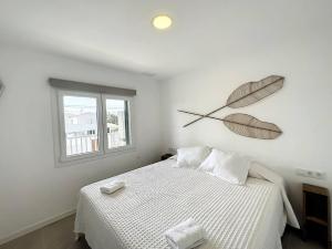 a bedroom with a bed with a clock on the wall at Ses Salines Apartments SAranalet in Fornells