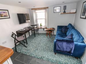 a living room with a blue couch and a table at Penpwmp in Newport