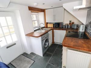 a kitchen with a sink and a washing machine at Penpwmp in Newport