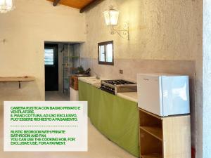 a kitchen with a counter with a refrigerator in it at Giardinello Stagnone Sunset in Marsala