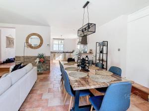 a living room with a table and blue chairs at The d'Isly House - Belle maison pour 8 personnes in Carcassonne