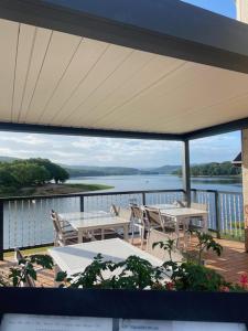 a balcony with tables and chairs and a view of the water at LES TERRASSES DU LAC in Chaumard