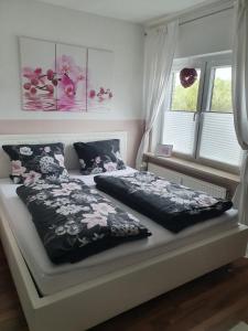 1 cama con edredón blanco y negro y 2 ventanas en Ferienwohnung Mühlenhof en Duderstadt