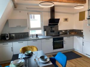 a kitchen with white cabinets and a table with blue chairs at Stilvolles Appartement im Herzen Bambergs in Bamberg +20 photos