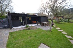 a backyard with a picnic table and a house at Waen las Cabin in Denbigh