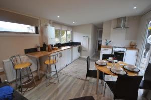 a kitchen with a table and chairs in a room at Waen las Cabin in Denbigh
