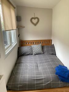 a bed in a bedroom with a heart on the wall at Waen las Cabin in Denbigh
