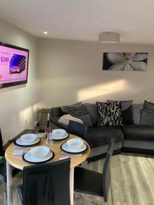 a living room with a table and a couch at Waen las Cabin in Denbigh