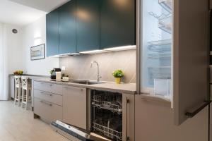 a kitchen with green cabinets and a sink at Terminal Tower 601 - San Cristoforo M4 in Milan +32 photos