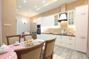 a kitchen with a table and chairs and a kitchen with white cabinets at Ekskluzywny apartament w pałacu z parkiem Palac Chociule in Świebodzin