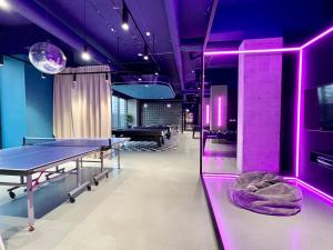 a room with ping pong tables and purple lighting at Chillout Dorm Cracow by BookingHost in Krakow